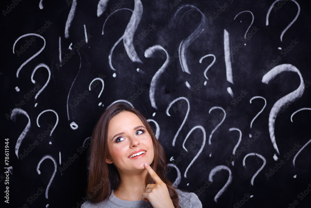 Young girl with question mark on a gray background Young girl with question mark on a gray background