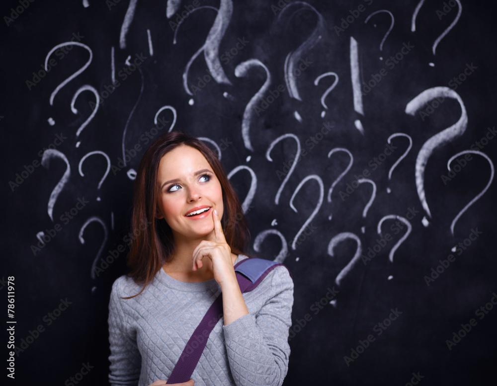 Young girl with question mark on a gray background Young girl with question mark on a gray background