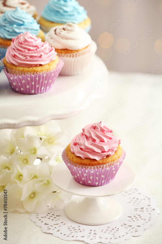 Delicious cupcakes on table on light background Delicious cupcakes on table on light background