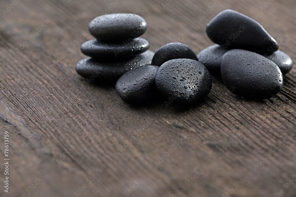 Stack of black sea paddles on rustic wooden background Stack of black sea paddles on rustic wooden background
