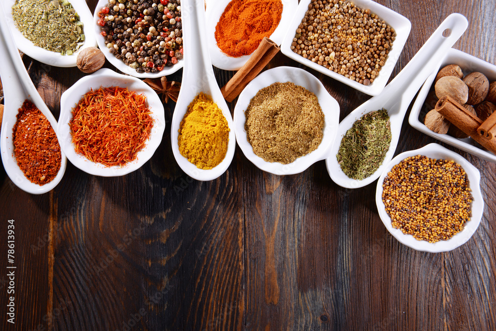 Different kinds of spices in ceramics bowls and spoons Different kinds of spices in ceramics bowls and spoons