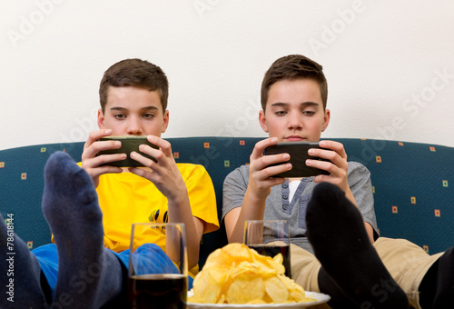 Zwei Jungen mit Smartphone auf der Couch