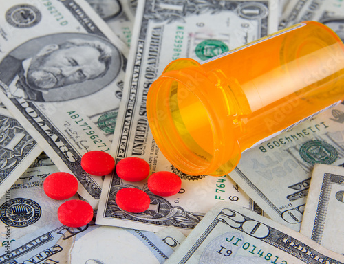 Pill box and pills on dollars
