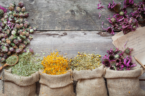 Healing herbs in hessian bags on old wooden rustic table, herbal photo