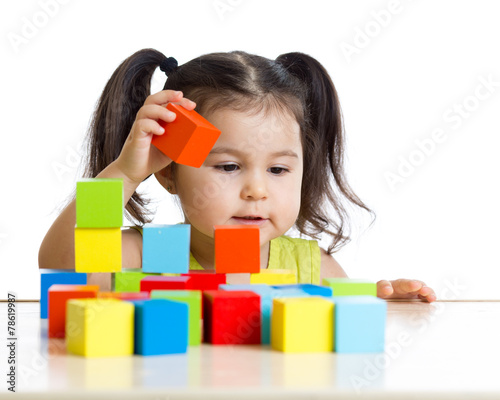 toddler girl builds a tower...