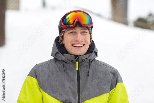 happy young man in ski goggles outdoors
