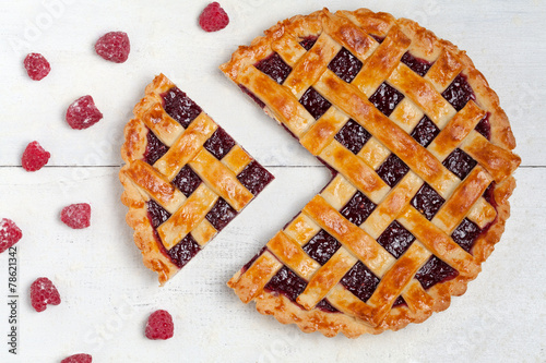 Fotografia Sliced raspberry pie with fresh raspberries on white table