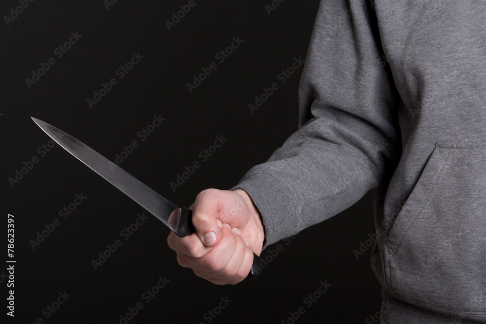 close up of knife in male hand over grey