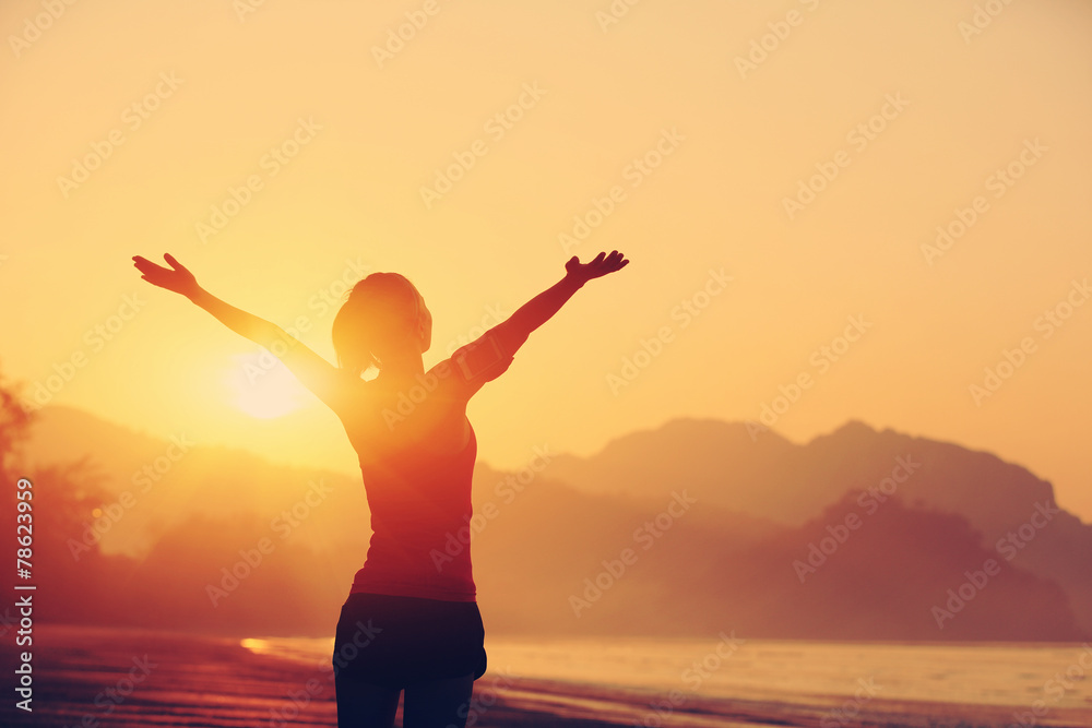 cheering woman hiker open arms at sunrise seaside beach 