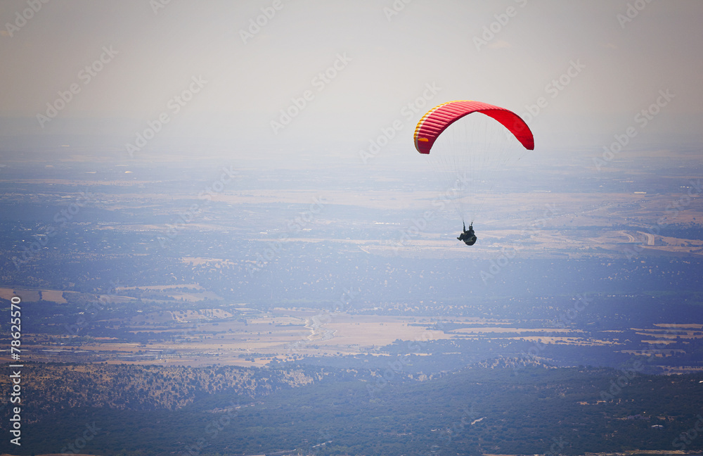 Paraglider flying over El Escorial Paraglider flying over El Escorial