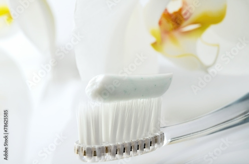 toothbrush with toothpaste on a white table against the backgrou