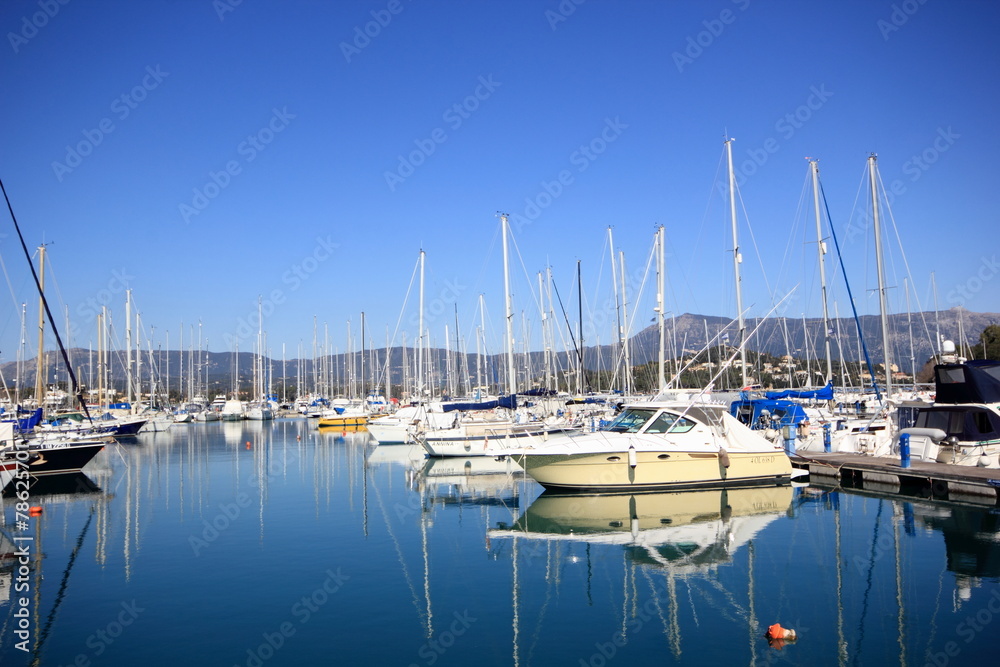 Yachts and sail boats reflected in a Marina harbour