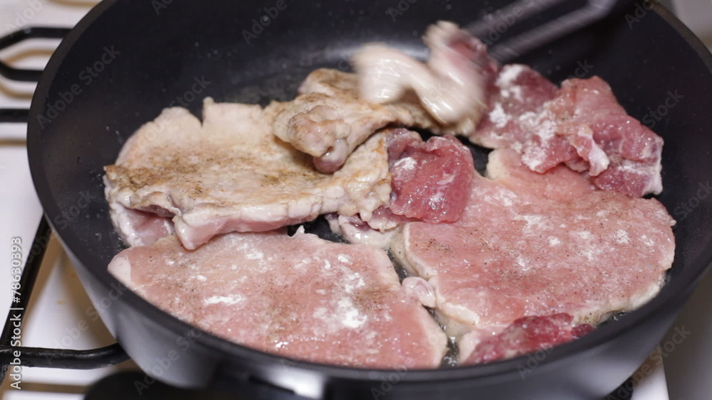 Frying and turning pork meat with fork on the pan. Frying and turning pork meat with fork on the pan.