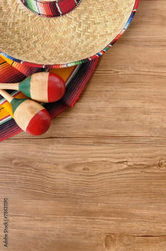 Mexican background sombrero with maracas and traditional serape blanket on natural wood floor Mexico cinco de mayo fiesta