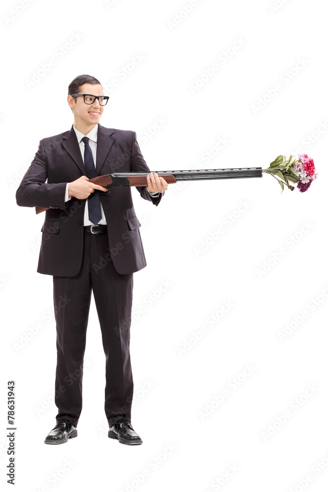 Businessman holding a rifle loaded with flowers Businessman holding a rifle loaded with flowers