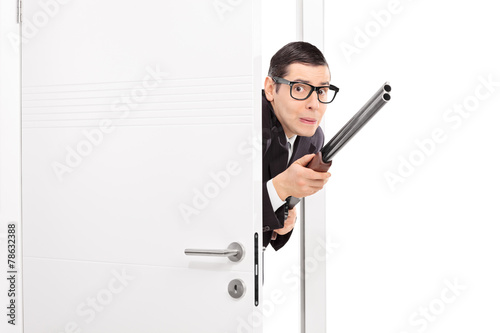 Terrified man with rifle entering a room