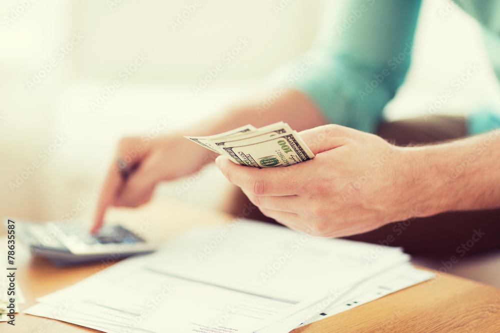 close up of man counting money and making notes close up of man counting money and making notes