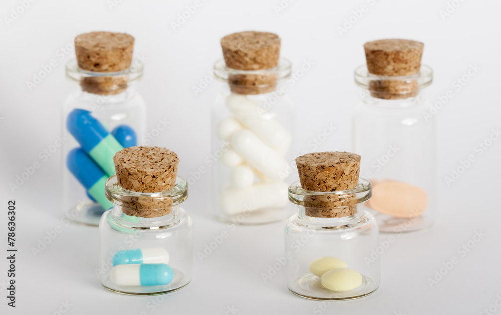 five bottles with colorful pills
