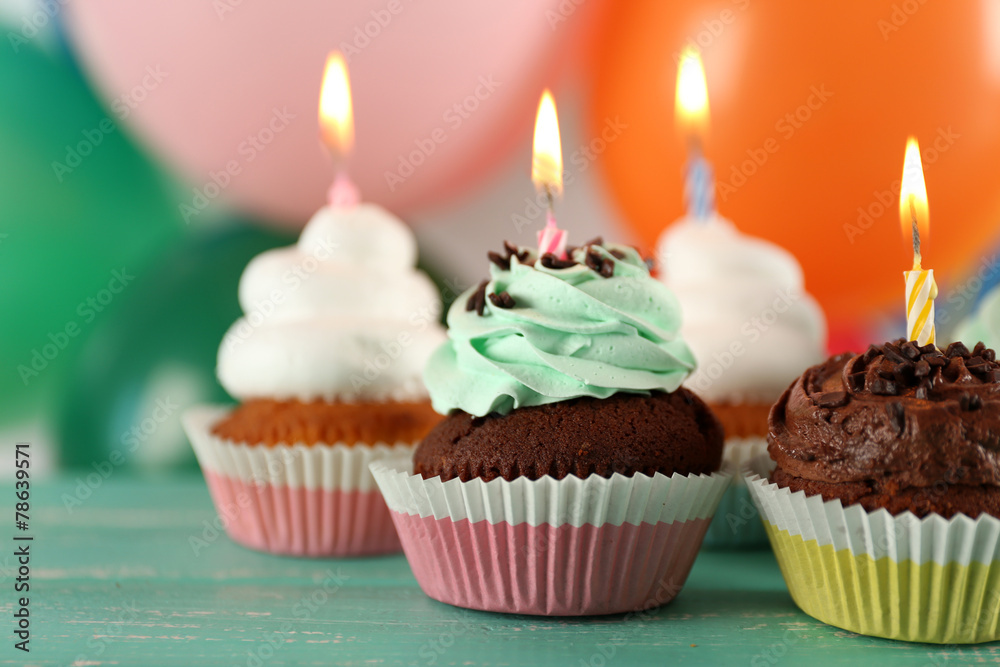 Delicious birthday cupcakes on table on bright background Delicious birthday cupcakes on table on bright background