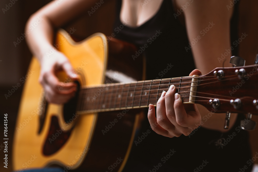 Obraz premium woman's hands playing acoustic guitar, close up