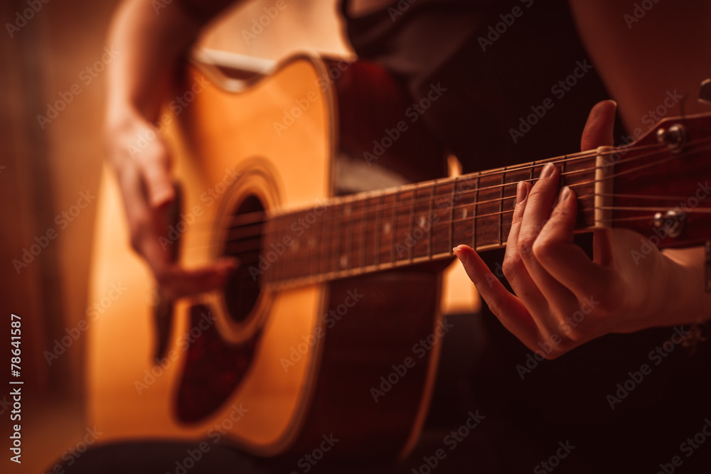 Fototapeta premium woman's hands playing acoustic guitar, close up