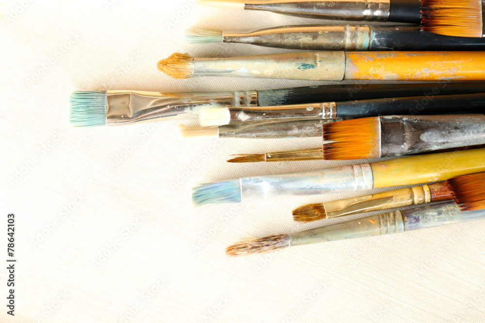 Obraz premium Different paintbrushes on fabric background