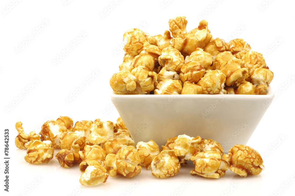 pieces of caramel popcorn in a bowl on a white background pieces of caramel popcorn in a bowl on a white background