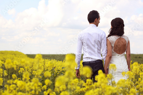 Bride and groom posing in the fields
