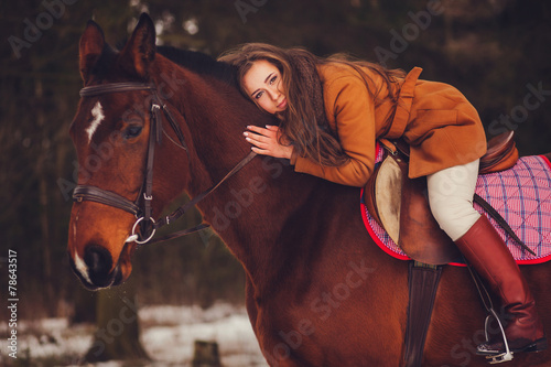 beautiful girl with long hair sitting on a horse