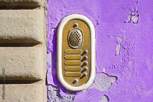 Old colored bell system on purple plaster (Tuscany - Italy) photo