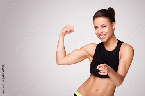 Foto Mixed race woman demonstrating biceps