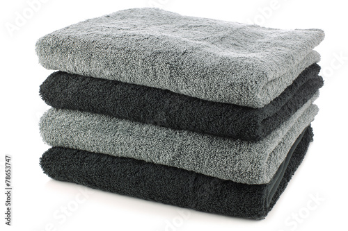 stacked black and grey bathroom towels on a white background photo
