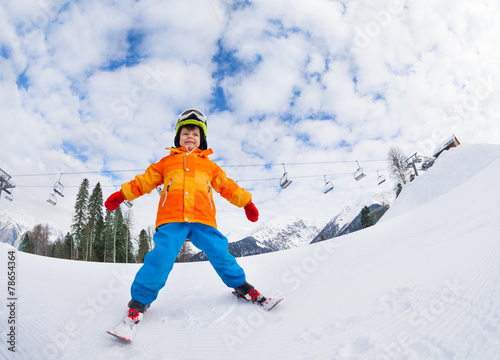 Boy with mask and helmet skiing on ski resort