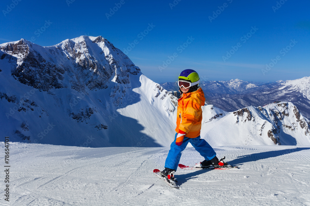 Boy in mask skiing with beautiful mountain view