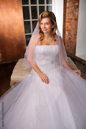 beautiful bride sitting posing in her wedding dress. Studio.