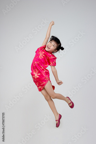 Portrait of happy little Asian child jumping to the air
