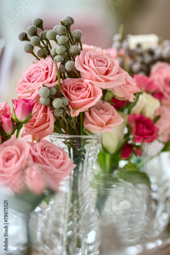 Bouquets of roses on a festive wedding table in the restaurant.