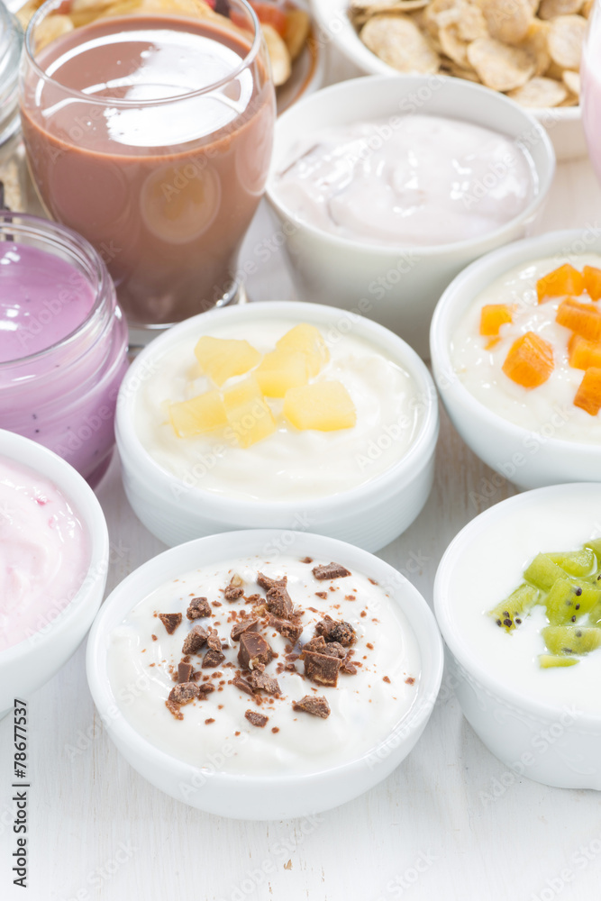 Assorted fruit yoghurts and breakfast ingredients, vertical Assorted fruit yoghurts and breakfast ingredients, vertical