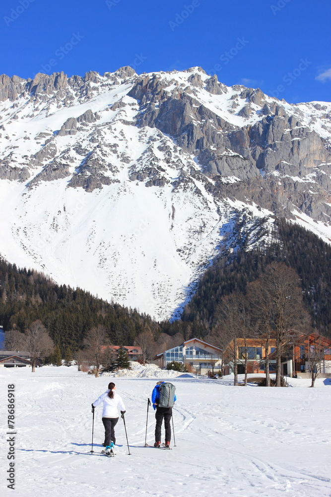 Zwei Tourengeher mit Ski am Fuße des Dachstein