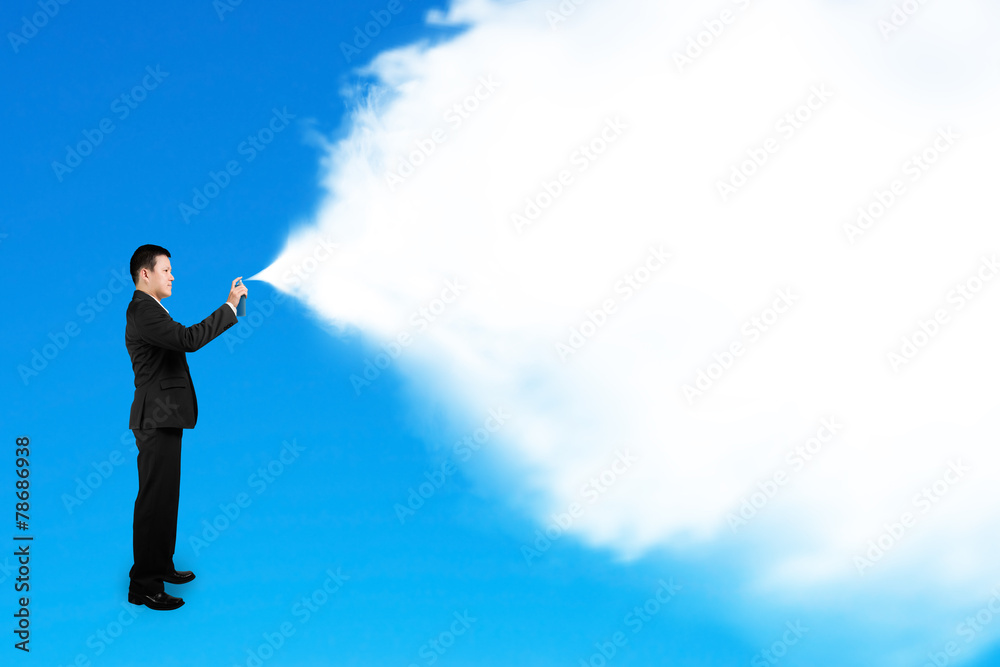 Business man spraying white cloud paint isolated on blue Business man spraying white cloud paint isolated on blue