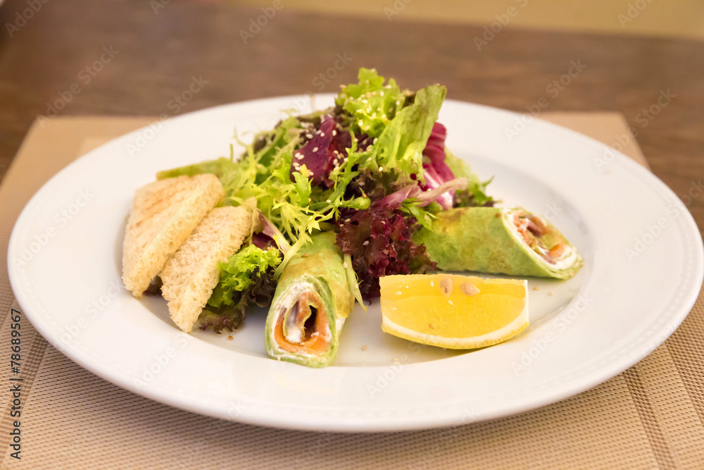 Spinach crepes with salmon and salad mix