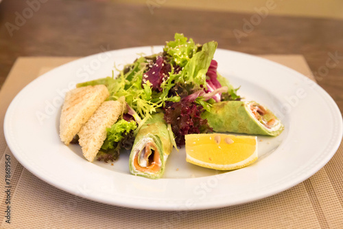 Spinach crepes with salmon and salad mix