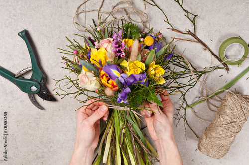 Fototapeta Naklejka Na Ścianę i Meble -  hands of florist making bouquet spring flowers
