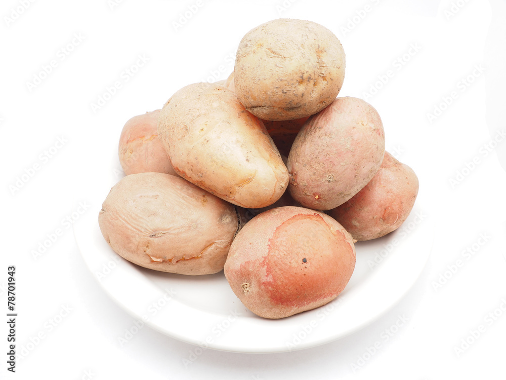 unpeeled potatoes on a white background unpeeled potatoes on a white background