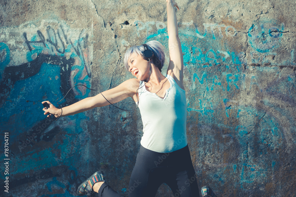 Obraz premium young beautiful short blue hair hipster woman with headphones mu