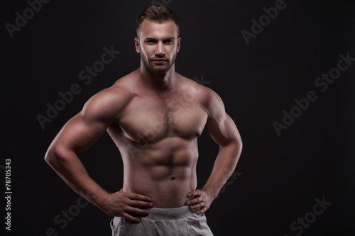 muscular man isolated on black background © Aleksandr Doodko