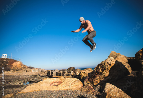 man performs freerunning jump on stones