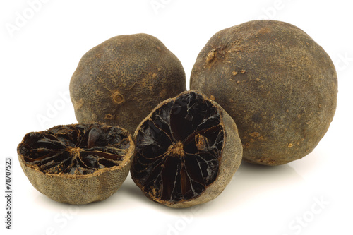 dried "black lime"fruit and a cut one on a white background