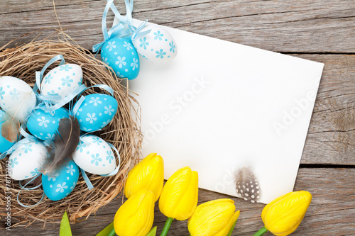 Easter greeting card with blue and white eggs and yellow tulips