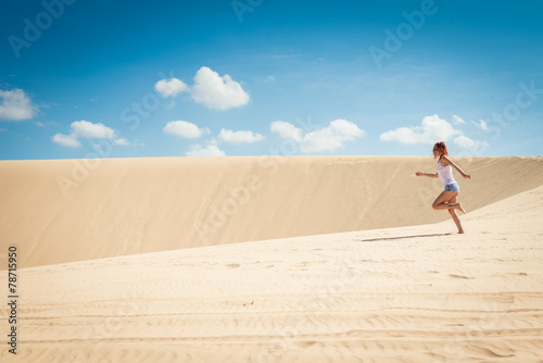 Young woman running on dunes